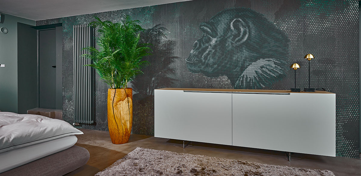 Nachhaltiger Heimatgruß Ökologisches Produkt aus heimischen Wäldern: Das aus einem einzigen Eichenstamm gedrechselte Pflanzgefäß bindet und spart dank kürzester Trans- portwege CO2. Ansprechend gepaart mit einer künstlichen Areca-Palme.