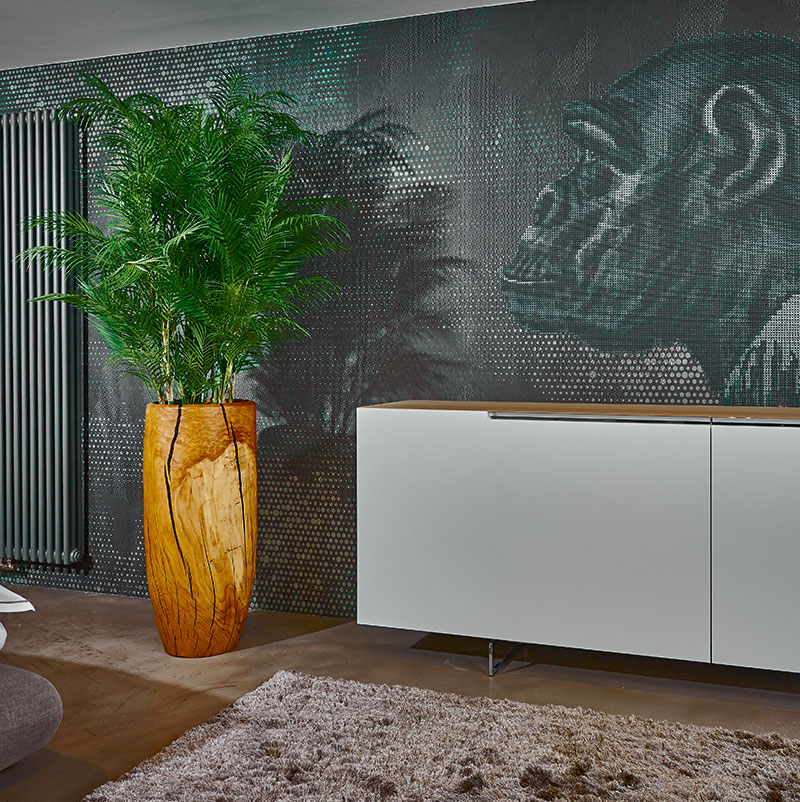 Nachhaltiger Heimatgruß Ökologisches Produkt aus heimischen Wäldern: Das aus einem einzigen Eichenstamm gedrechselte Pflanzgefäß bindet und spart dank kürzester Trans- portwege CO2. Ansprechend gepaart mit einer künstlichen Areca-Palme.