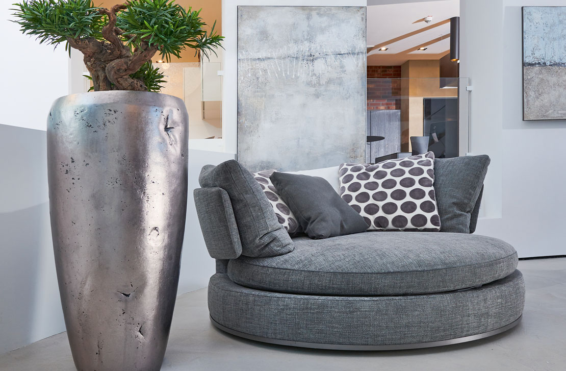 Fels in der Brandung Über ein Meter hohes RAW Gefäß in Silber. Bepflanzt mit einem künstlichen Podocarpus – von Terra Viridis in handwerklicher Feinarbeit auf einem echten Rebstockstamm aufgebaut